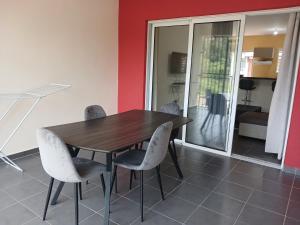 - une salle à manger avec une table et des chaises en bois dans l'établissement Le T3 de l'Ouest, à Saint-Laurent du Maroni