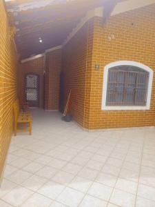 Cette chambre est dotée d'un mur en briques jaunes et d'une fenêtre. dans l'établissement Casa a meia quadra da Praia do Caiçara PG, à Solemar