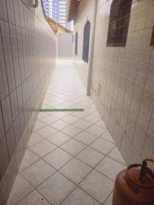 un couloir vide avec du carrelage dans un bâtiment dans l'établissement Casa a meia quadra da Praia do Caiçara PG, à Solemar