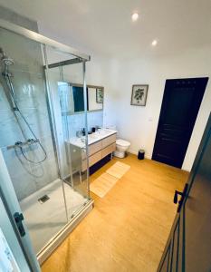 een badkamer met een glazen douche en een toilet bij Evasion tropicale in Bretteville-sur-Odon