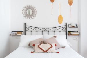 ネルハにあるApartamento Serendipia Nerjaのベッドルーム(ハートピロー付きの白いベッド付)