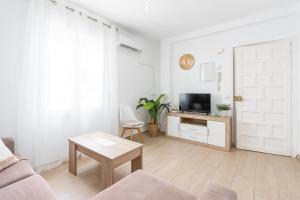 ネルハにあるApartamento Serendipia Nerjaのソファとテレビのある白いリビングルーム