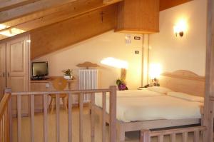 a bedroom with a large bed and a television at Hotel Sciatori in Livigno