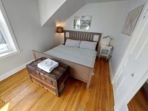 Cama pequeña en habitación con suelo de madera en Doucet Guesthouse, en Hamilton