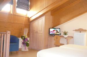 a bedroom with a bed and a tv on a wall at Hotel Sciatori in Livigno