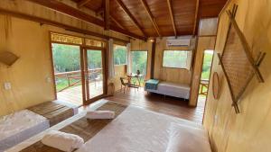 a room with a bed and a bedroom with a balcony at Bioma EcoLodge in Iranduba