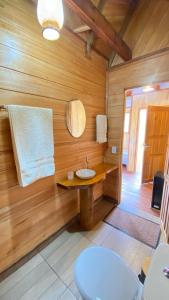 uma casa de banho com um lavatório numa parede de madeira em Bioma EcoLodge em Iranduba