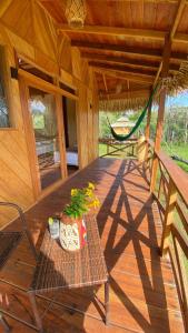 a porch of a cabin with a table and a plant at Bioma EcoLodge in Iranduba