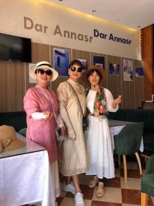 three women are posing for a picture in a store at Hotel Dar Annasr in Chefchaouene