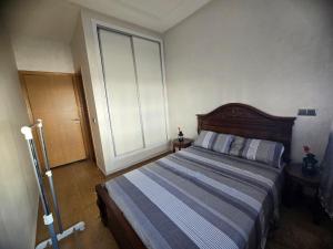 een slaapkamer met een bed en een groot raam bij Résidence Perla Andaloussia in Mansouria