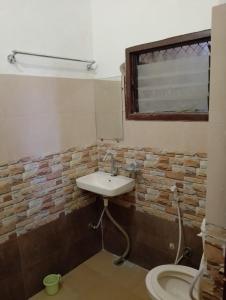 a bathroom with a sink and a brick wall at Paarijat PG in Udaipur