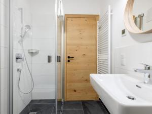 Un baño con lavabo, ducha y espejo. en Lärchenhof Top 302, en Mauterndorf 35 fotos más
