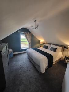 Un dormitorio con una cama grande y una ventana en New 3 bedroom apartment by the beach Belmullet., en Belmullet