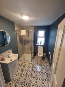a bathroom with a shower and a sink and a toilet at New 3 bedroom apartment by the beach Belmullet. in Belmullet