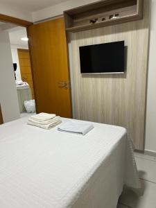 a bedroom with a bed with a tv on a wall at Apt Completo no West Flat in Mossoró