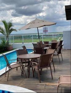 a patio with a table and chairs and an umbrella at Apt Completo no West Flat in Mossoró