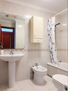 a bathroom with a sink and a toilet and a mirror at Habitación compartido Huelva centro in Huelva