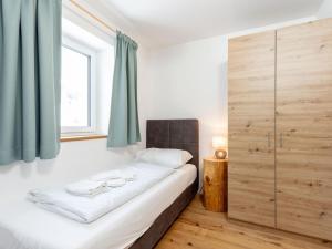 a bedroom with a bed with a large wooden cabinet at Lärchenhof Top 202 in Mauterndorf +38 photos