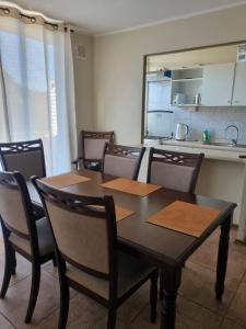 uma sala de jantar com mesa e cadeiras e uma cozinha em Ovalle Hotel Arauco em Ovalle