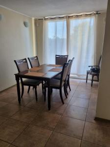 ein Esszimmer mit einem Tisch, Stühlen und einem Fenster in der Unterkunft Ovalle Hotel Arauco in Ovalle