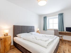 a bedroom with a large bed and a window at Lärchenhof Top 203 in Mauterndorf +40 photos