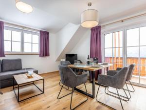 Una sala de estar con una mesa y sillas y un sofá. en Lärchenhof Top 301, en Mauterndorf