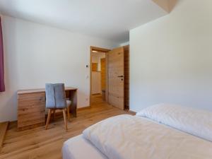 a bedroom with a bed and a desk and a chair at Lärchenhof Top 303 in Mauterndorf