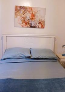 1 cama en un dormitorio con una pintura en la pared en Apartamento Vista Mar, en Río de Janeiro