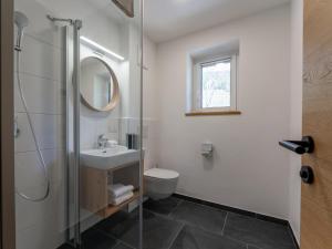a bathroom with a sink and a toilet and a mirror at Lärchenhof Top 303 in Mauterndorf +55 photos