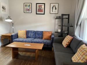 sala de estar con sofá azul y mesa en Doucet Guesthouse, en Hamilton