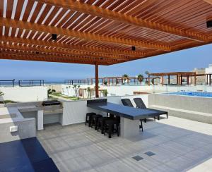 een patio met een blauwe tafel en stoelen en een zwembad bij Casa de estreno en Playa Azul in Cerro Azul