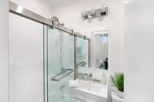 uma casa de banho com uma cabina de duche em vidro e um lavatório. em 444-2C Newly renovated 1BR in Hell's Kitchen em Nova York
