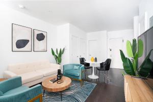 uma sala de estar com um sofá, cadeiras e uma mesa em 444-2C Newly renovated 1BR in Hell's Kitchen em Nova York