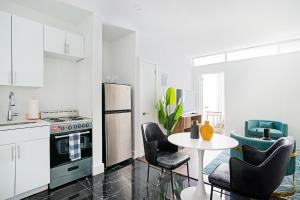 ニューヨークにある444-2C Newly renovated 1BR in Hell's Kitchenのキッチン(コンロ、テーブル、椅子付)