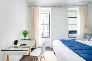 ニューヨークにある444-2C Newly renovated 1BR in Hell's Kitchenのベッドとテーブルと机のある寝室