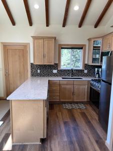 uma cozinha com armários de madeira e um frigorífico preto em HideAway Chalet em Bend