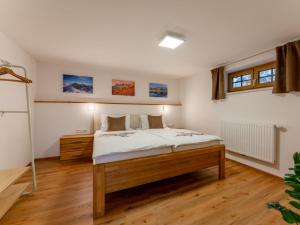 1 dormitorio con 1 cama con sábanas blancas y suelo de madera en Bienenheim, en Schladming