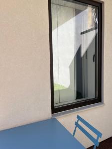 uma mesa azul e uma janela num quarto em JM Alojamento local no Porto no Porto