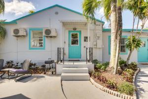 una casa bianca con una porta blu e palme di Hollywood Beach Bungalow Near Golf Pets Welcome! a Hollywood