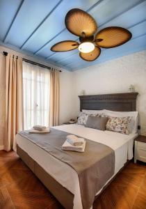 a bedroom with a large bed with two ceiling fans at Petite Boutique Hotel in Ildır