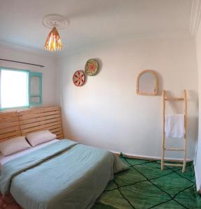 a bedroom with a bed and a chair in it at Surfpoint Tamraght in Tamraght Oufella