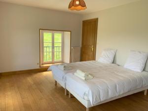 1 dormitorio con 1 cama blanca grande y toallas. en Gite du Moulin, en Guignicourt-sur-Vence