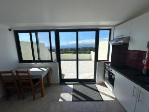 a kitchen with a table and a view of a balcony at AL Novavista by BPX in Madalena