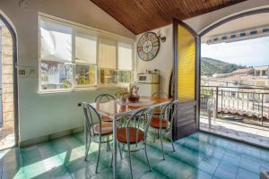 una cucina con tavolo e sedie e un balcone di Apartments by the sea Stupin Celine, Rogoznica - 4264 a Rogoznica (Rogosnizza)