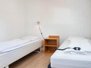 エーベルトフトにあるHoliday home Ebeltoft XXVIのベッド2台、テーブル(ランプ付)が備わる客室です。