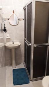 a bathroom with a sink and a shower with a mirror at Apartamento Vista Mar in Rio de Janeiro