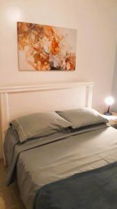1 cama en un dormitorio con una pintura en la pared en Apartamento Vista Mar, en Río de Janeiro