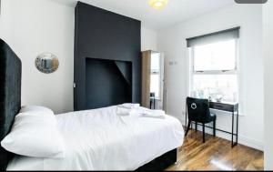 a bedroom with a white bed and a desk at Cambridge House Hotel in Cambridge