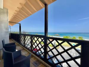 a balcony with chairs and a view of the beach at Araha Resort Arapana in Chatan