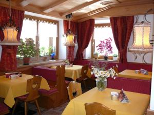 a restaurant with tables and chairs and windows at Hotel Sciatori in Livigno